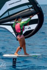 Wing foiler riding with a Kaohi bungee wing leash on the wrist