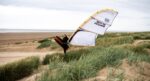 Rider jumping the Cabrinha Switchblade Design Works over the dunes