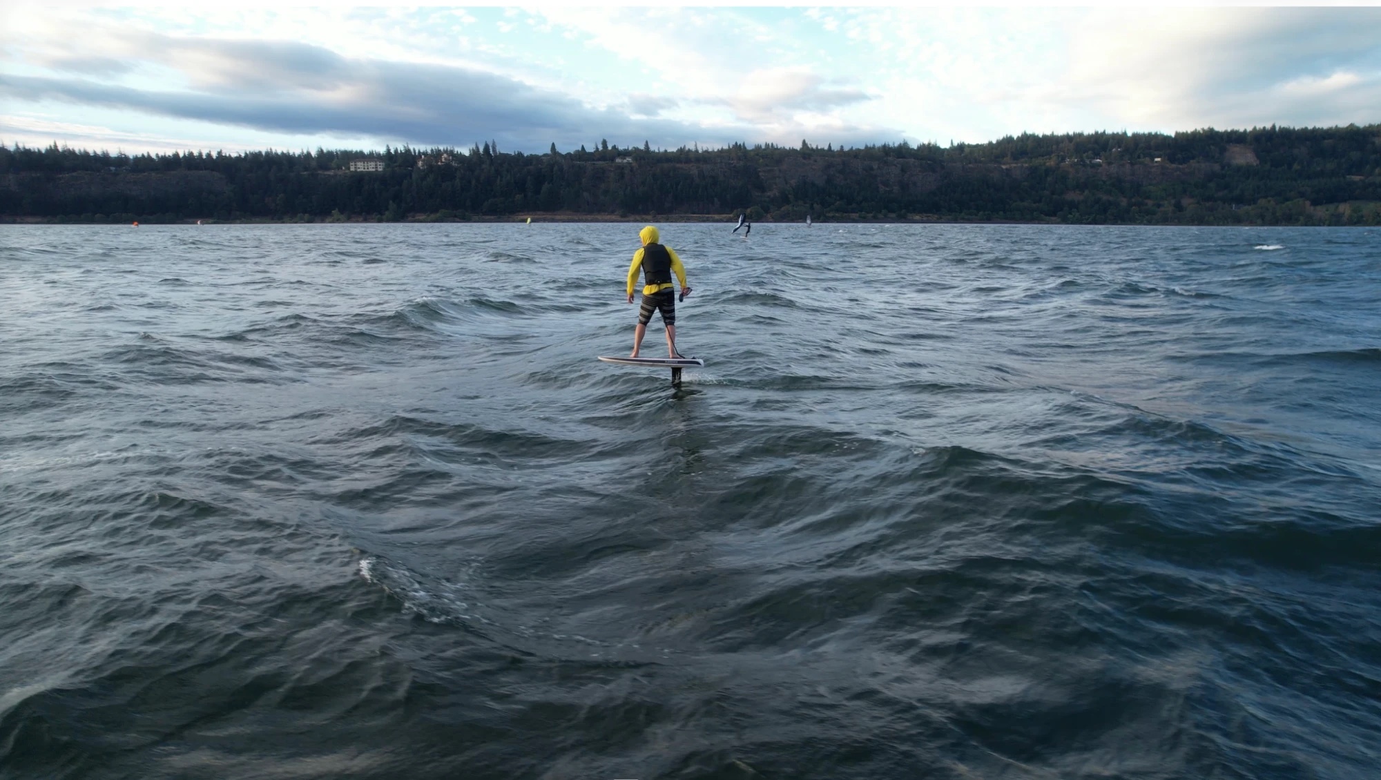 tj-liftx-yellow-hoodie-closer-hatchery-dan-gavere eFoiler with a bright yellow hood pulled over his helmet and a life vest on the LiftX, Columbia River Gorge. Drone: Dan Gavere